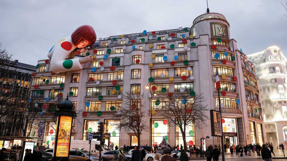 A giant clown embraces the façade of the Champs-Elysées