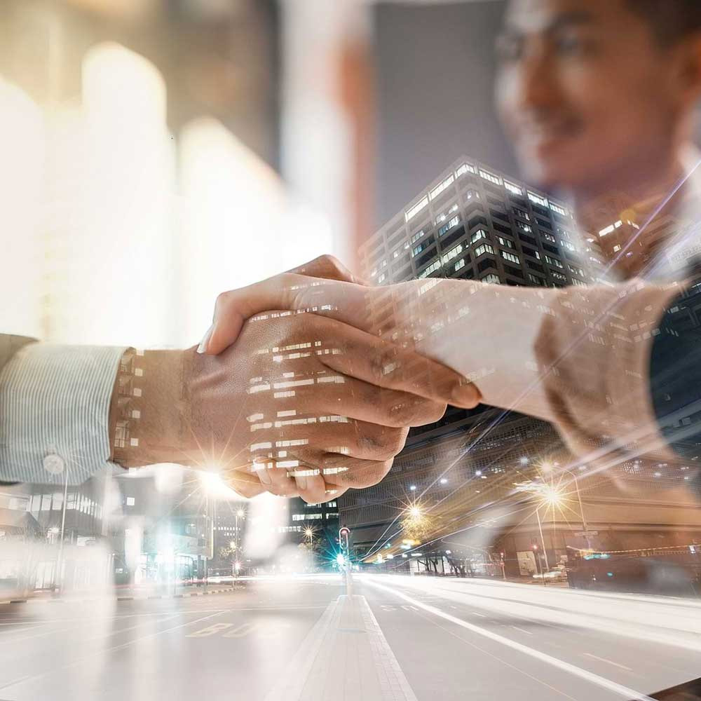 A handshake between business people. The picture contains illustrations that suggest digital processes.