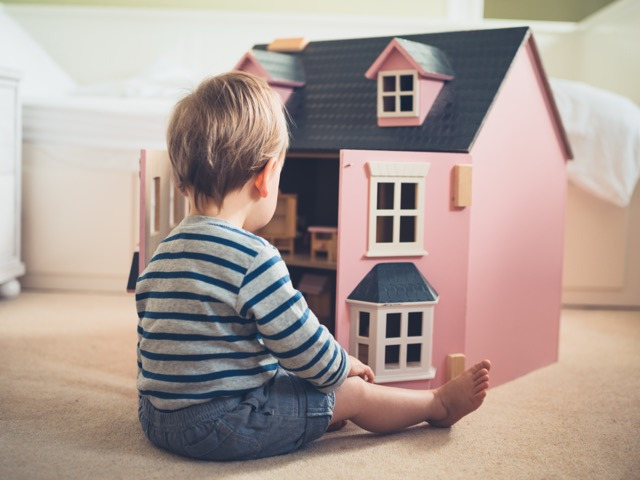 Junge mit Puppenhaus