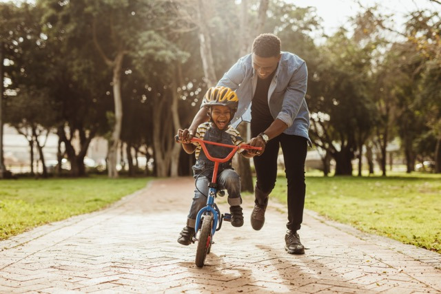 Vater bringt Sohn Fahrradfahren bei